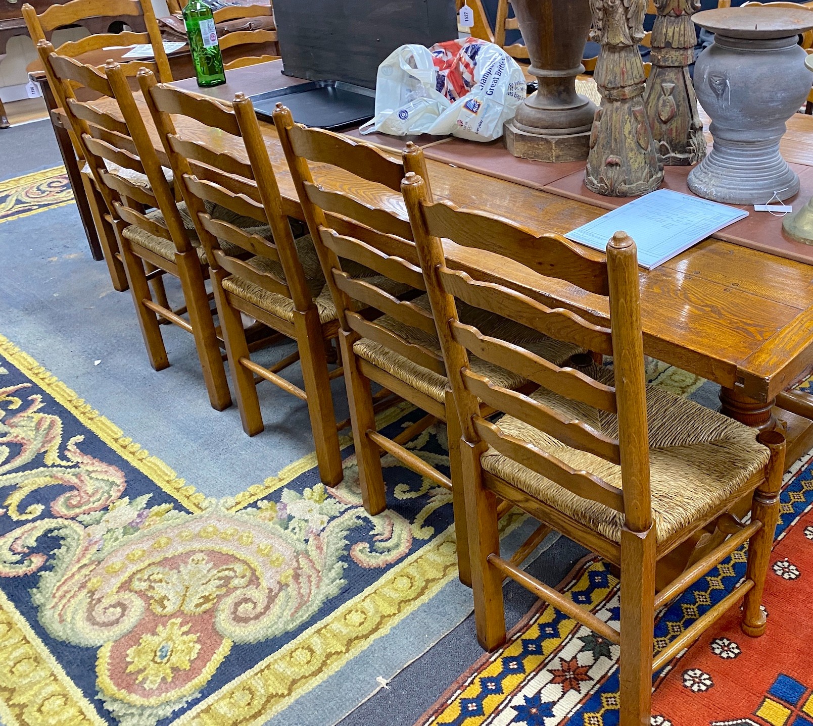 A good set of twelve reproduction Belvedere Furniture light oak ladderback dining chairs with drop in rush seats.